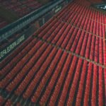 Rows of empty red seats in a UEFA Europa League stadium, captured from above.